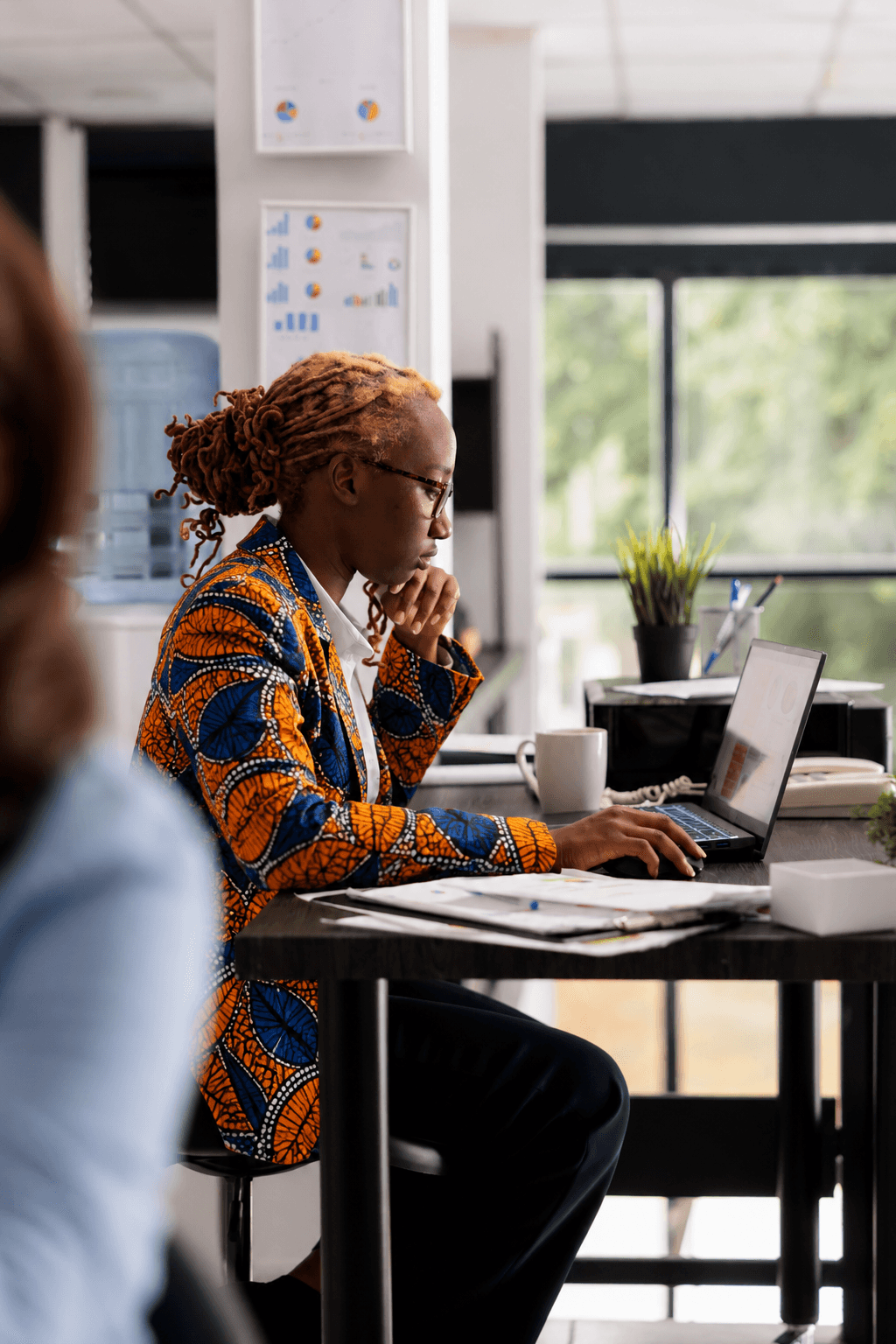 A professional smiling at her desk.